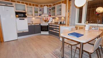 Een koelkast, een magnetron, een vaatwasser, kookgerei, borden en bestek