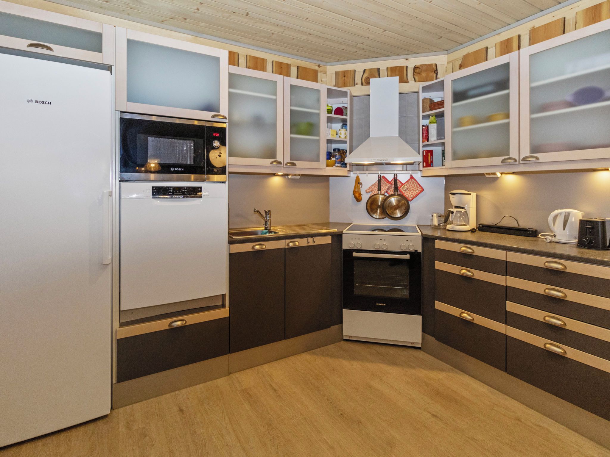 A kitchen with a Bosch refrigerator, microwave, oven, and stove.