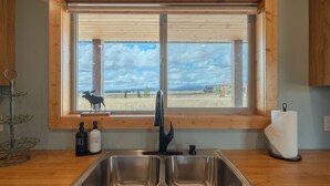 A kitchen with a large window, a stainless steel sink, and two soap dispensers. - Teton View Ranch! Hot Tub, Mountain Views & 35mi to Yellowstone! (Island Park)