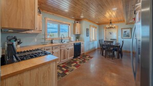 A kitchen with wooden cabinets, a gas stove, a dishwasher, and a refrigerator. - Teton View Ranch! Hot Tub, Mountain Views & 35mi to Yellowstone! (Island Park)