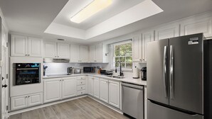 A modern kitchen with white cabinetry, stainless steel appliances, and a skylight. - NEW - Moody BBQ Retreat w/Covered Patio (Jackson)