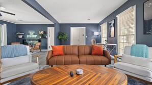 A modern living room with a brown sectional sofa, two white armchairs, and a wooden coffee table. - NEW - Moody BBQ Retreat w/Covered Patio (Jackson)