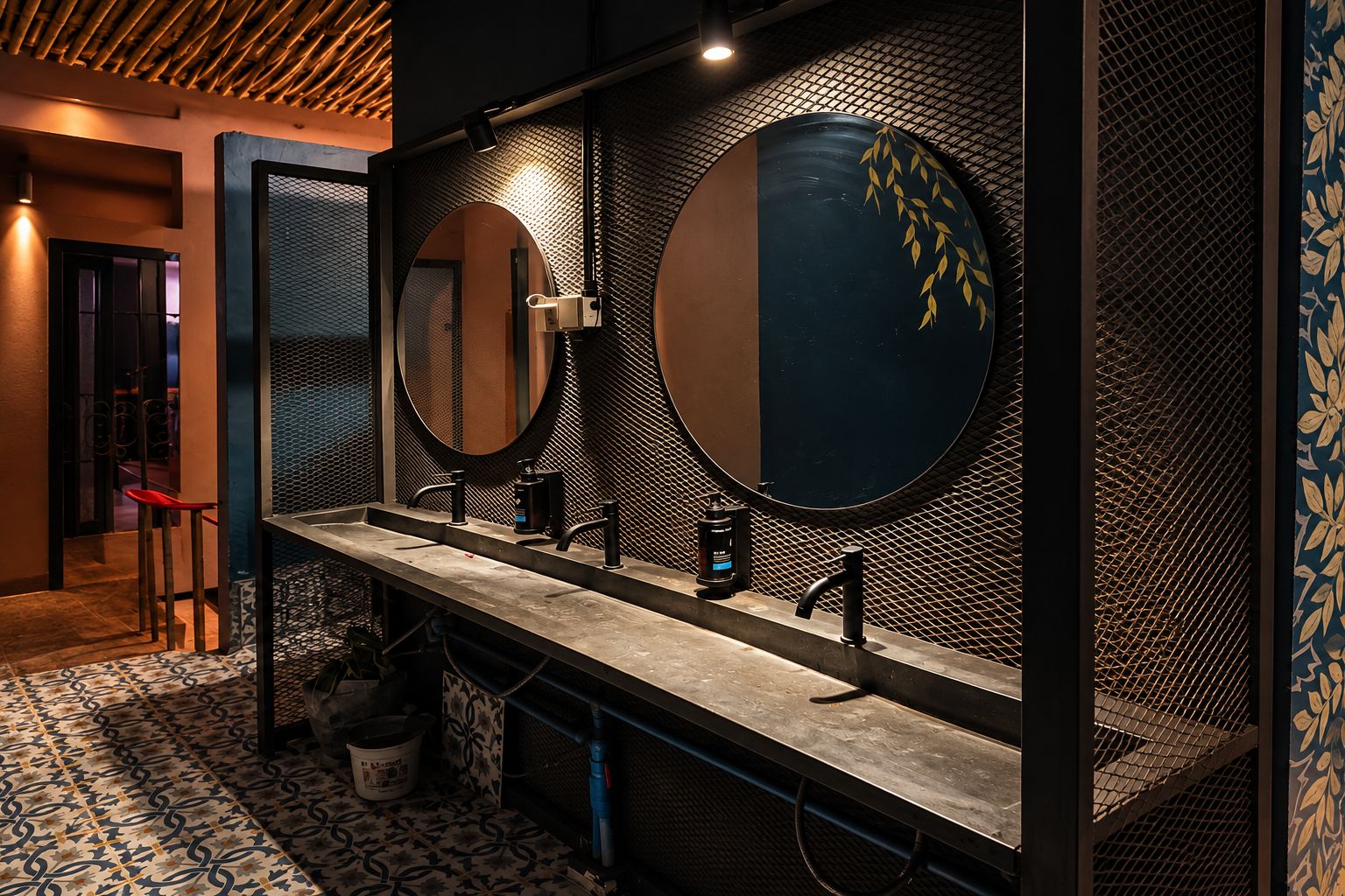 A modern bathroom with a long vanity, two round mirrors, and a patterned floor.