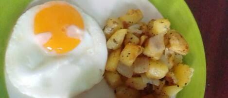 A plate with a fried egg and seasoned potatoes.