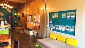 Un espace d’accueil comprenant un comptoir, des sièges et un panneau d’affichage où sont accrochées des affiches d’information.