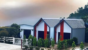 Un edificio moderno con fachada blanca, detalles en rojo y techo inclinado.