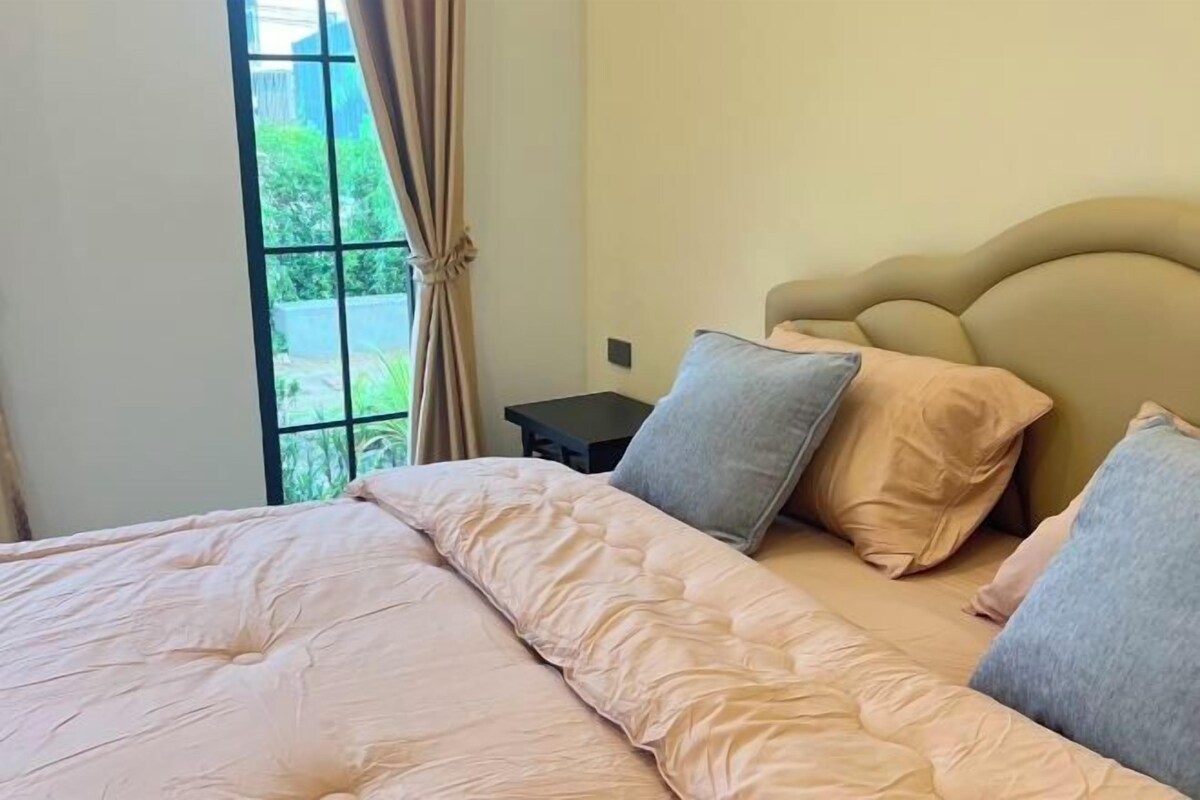 Een slaapkamer met een groot bed, een hoofdbord en een nachtkastje.