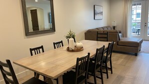 A dining area with a wooden table and chairs, a mirror, and a framed picture on the wall. - Charming 3-bedroom townhome with WiFi, AC in wonderful Washington (Washington)