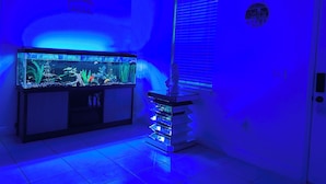 A room with a large aquarium, a small statue, and a 'Welcome' sign.