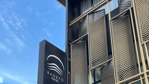 Un moderno edificio de hotel con un letrero llamativo que muestra el nombre 'BADETO HOTEL'.