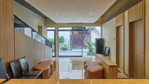 Un moderno vestíbulo de hotel con mostrador de recepción, zona de estar y vistas al exterior.