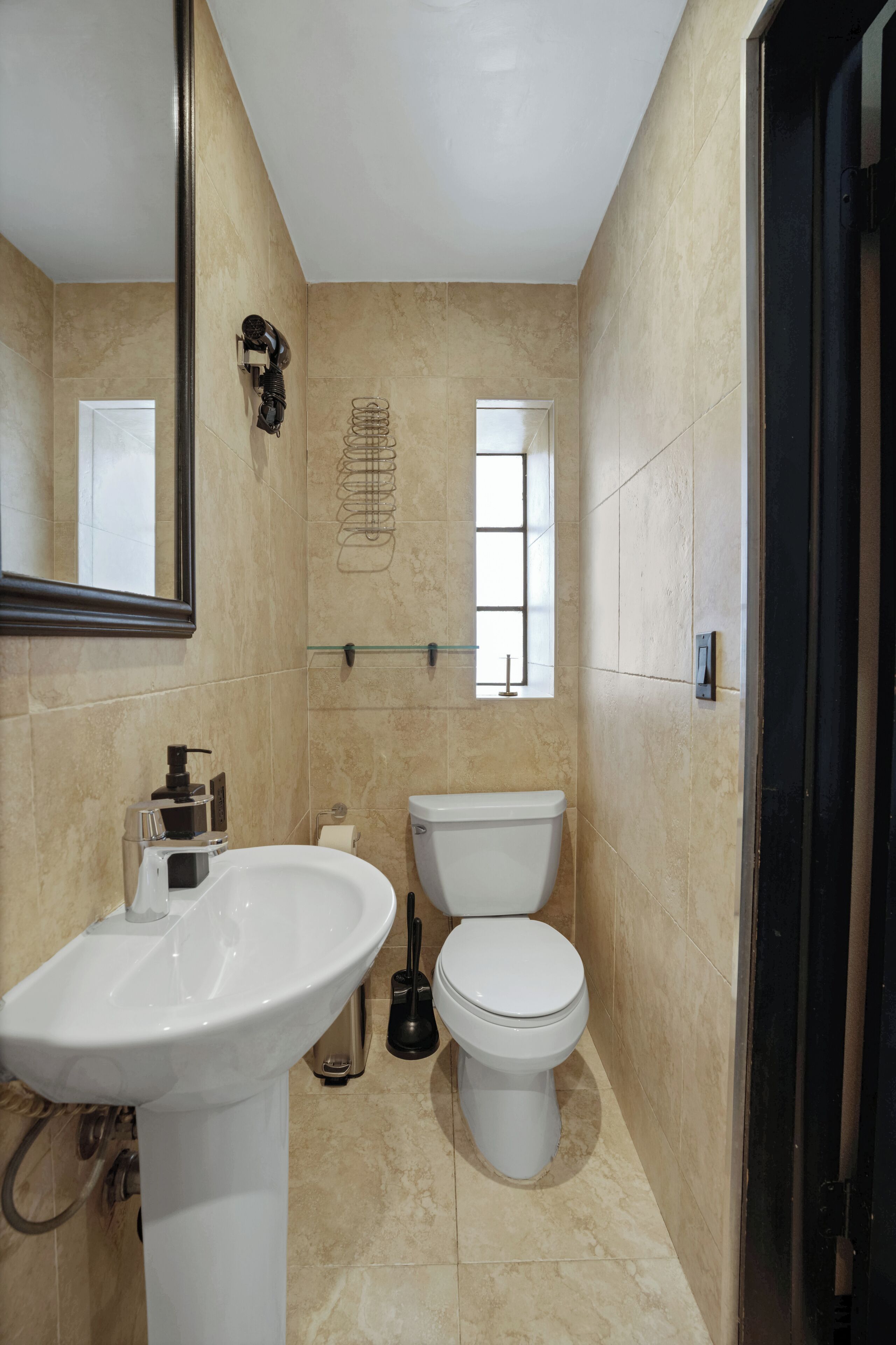 A bathroom with a white sink, toilet, and a towel rack.