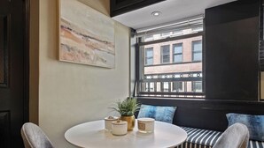 A cozy seating area with a round table, cushioned chairs, and a potted plant.