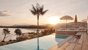 An infinity pool with a view of the sunset over a beach and mountains. - Isola Gerroa (Gerroa)