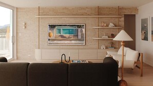 A modern living room with a large window, a fireplace, and a view of a pool. - Isola Gerroa (Gerroa)