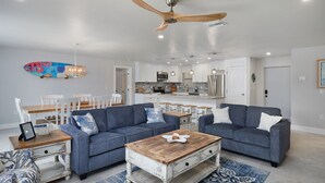 A modern living room with two sofas, a coffee table, and a dining area with chairs and a table. - Blind Pass C106  | Upgraded Ground Floor Residence at Blind Pass | Steps to Pool (Sanibel)