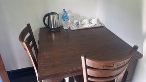 A wooden table with a kettle, water bottle, and teacups on a tray. - Eagles Eco Lodge - Kandy (Teldeniya)