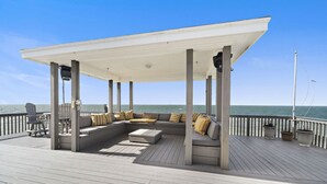 A covered outdoor seating area with a view of the ocean.