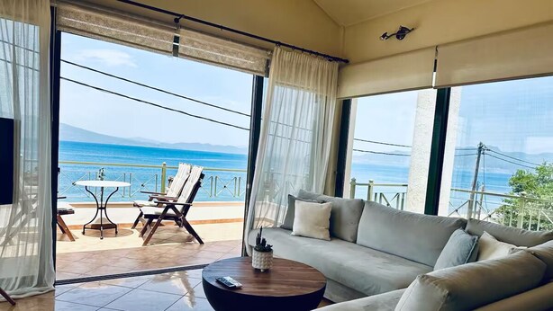 Un balcon spacieux avec un canapé, une petite table ronde et une table avec des chaises.