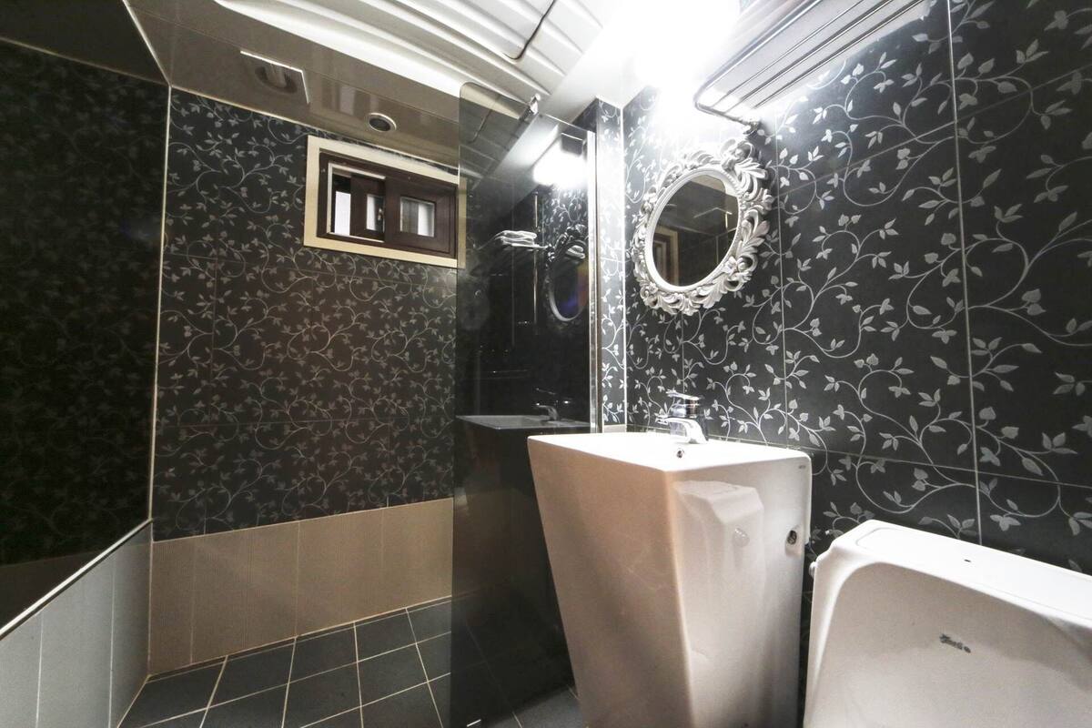 A bathroom with a toilet, sink, and mirror.