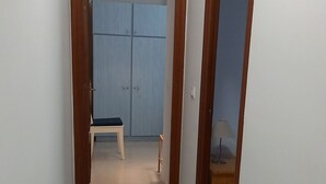 A hallway with a wooden door frame, a bench, and a wardrobe with a blue door. - Andalusia Tourist Accommodation (Córdoba)