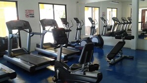 Ett gym med löpband, crosstrainers och en träningsbänk.