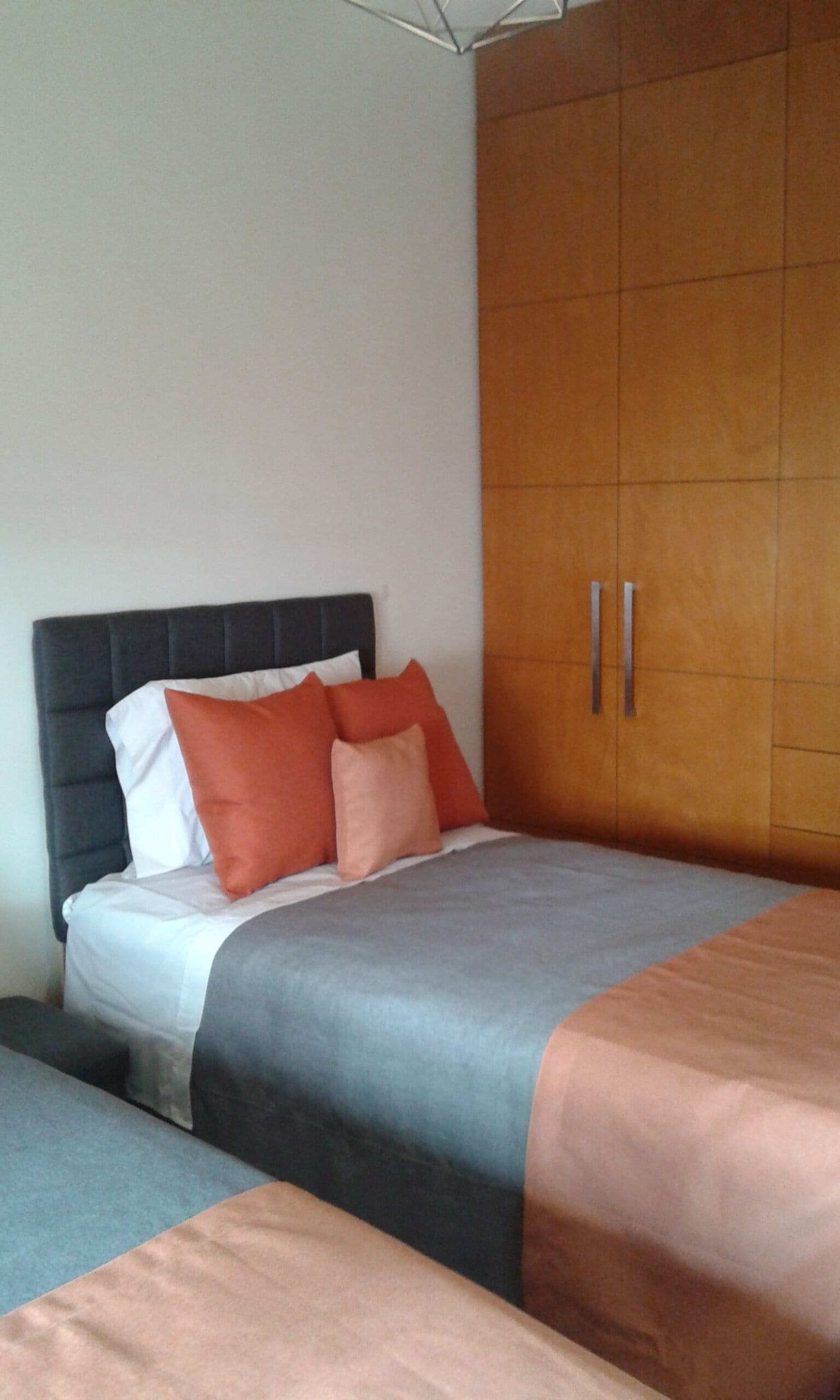A bedroom with a bed, a wardrobe, and a bedside table.