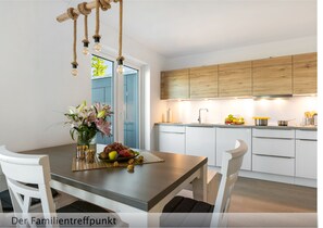Enjoy cooking in this well-equipped kitchen with an oven, white cabinetry, and a wooden countertop.
