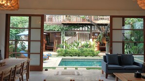 Un salón amplio con piscina, un sofá y una mesa de comedor.