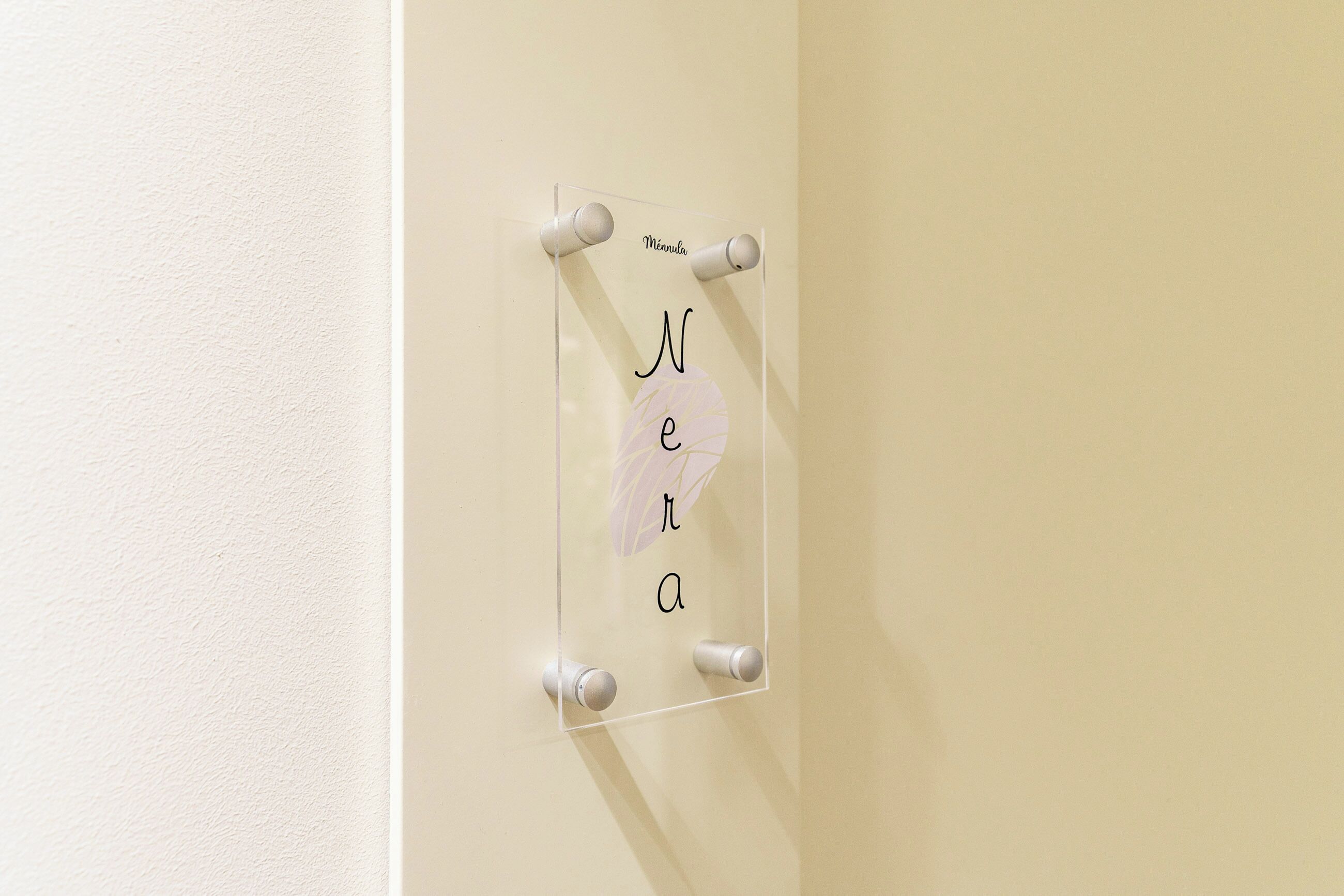 A clear glass display with the text 'Mennula' and 'Ne' on a wall.