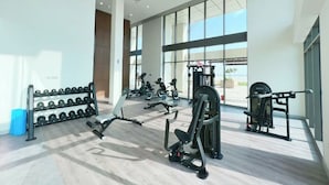 A modern gym with various exercise equipment, large windows, and a clean, spacious layout. - Bloomfields 1BR Azizi Farhad Burj View (Dubai)