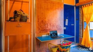A room with a desk, a chair, a laptop, a backpack, and a window with curtains. - goSTOPS Pondicherry Near Auroville (Auroville)