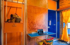 A room with a desk, a chair, a laptop, a backpack, and a window with curtains. - goSTOPS Pondicherry Near Auroville (Auroville)