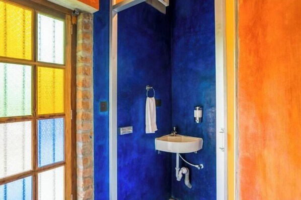 A bathroom with a blue wall, a white sink, and a towel hanging on the wall.