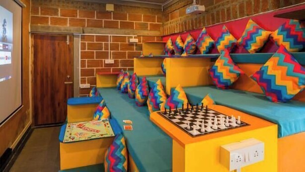 A theatre with colorful seating and a chessboard. - goSTOPS Pondicherry Near Auroville (Auroville)