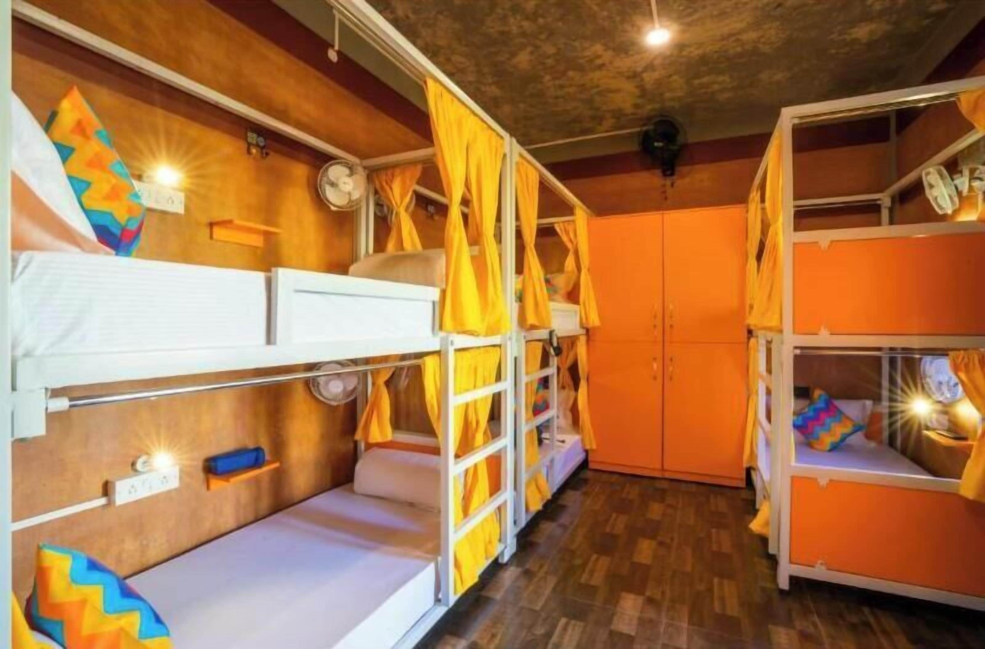 Una habitación con literas, paredes de madera y un ventilador de techo.