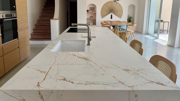 A modern kitchen with a marble countertop, built-in oven, and a staircase leading to another level. - Large renovated Mas provençale with swimming pool (Valréas)