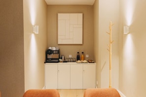 A room with a reception desk, a coffee machine, and a wall-mounted artwork. - Hotel PAX Atocha (Madrid)
