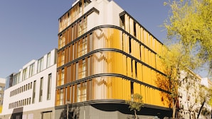 A modern building with a curved facade, large windows, and a balcony on the upper level. - Hotel PAX Atocha (Madrid)