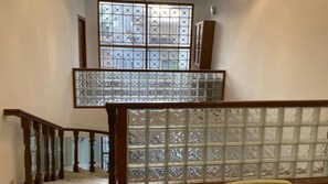 Una escalera con barandilla de madera y paneles de vidrio.