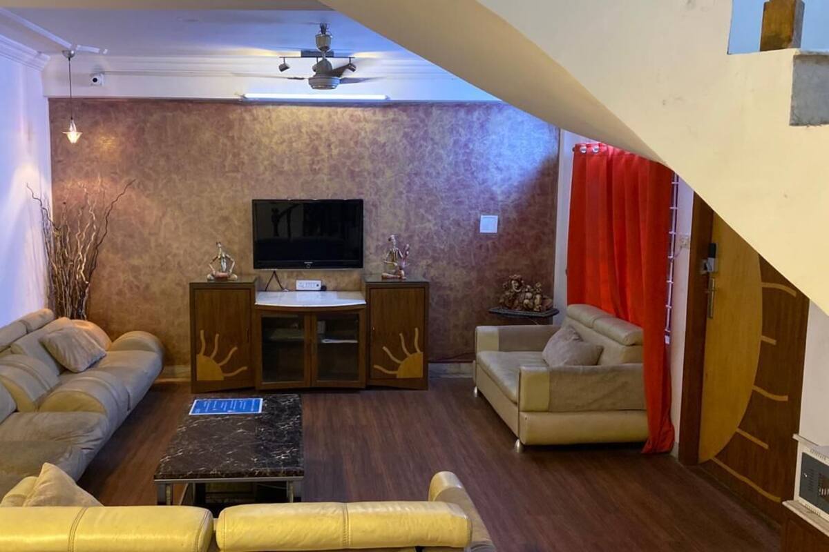 A living room with a sofa, a coffee table, a TV, and a fireplace.