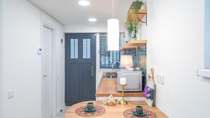 A modern kitchen with a wooden countertop, a gas stove, and a white refrigerator. - HB apartments Irakli Abashidze (Tbilisi)