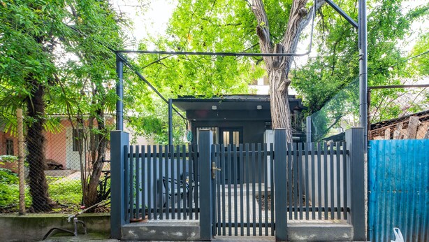 A gated area with a metal fence, steps leading to a covered entrance, and a tree in the background. - HB apartments Irakli Abashidze (Tbilisi)