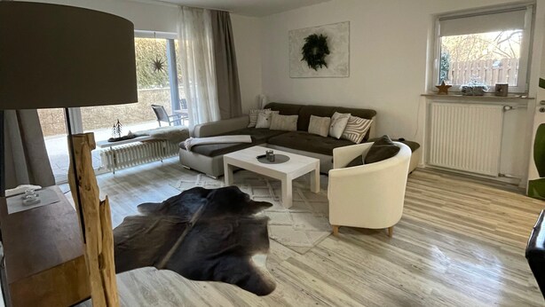 Un salon moderne avec un canapé, une table basse et un chien allongé sur le sol.