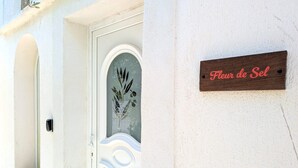 A white door with a glass panel and a wooden plaque that reads "Fleur de Sel". - Les Salines holiday home 5 minutes from the beach (Le Grau-du-Roi)