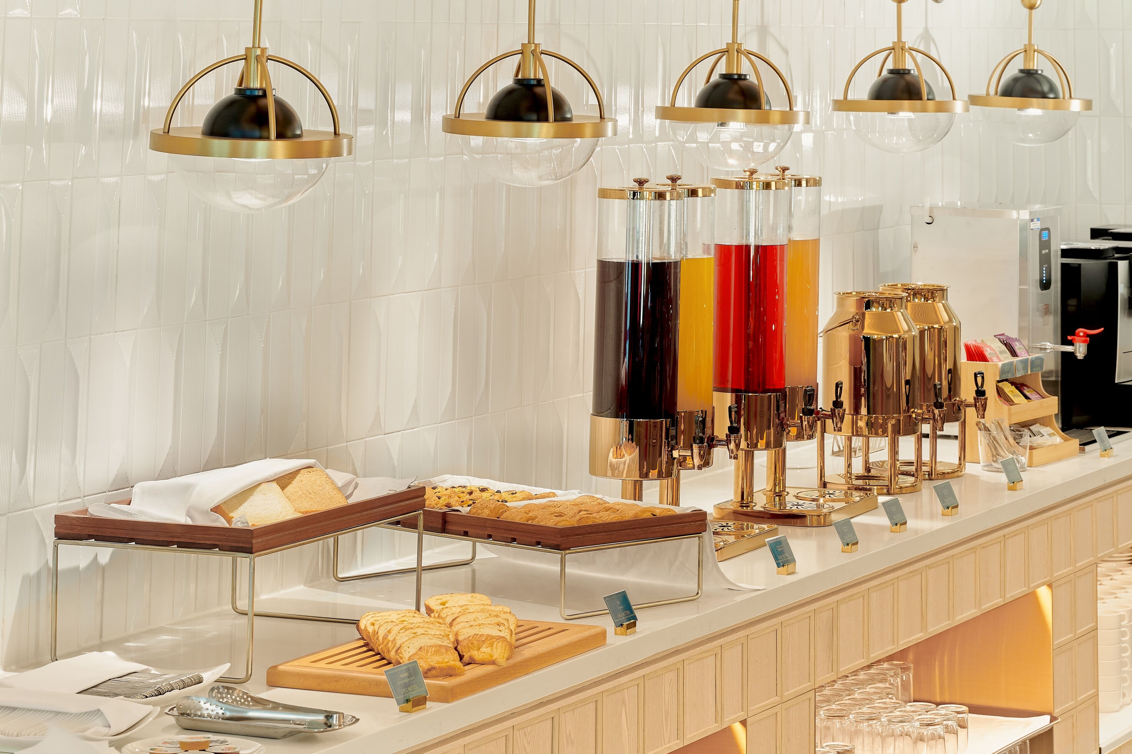 A breakfast buffet with various food items, a coffee machine, and a refrigerator.