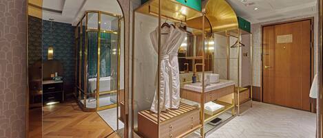 A bedroom with a four-poster bed, a vanity with a mirror, and a wooden wardrobe.
