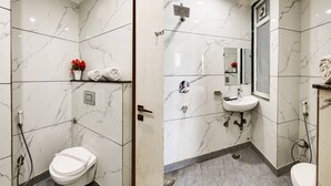 A modern bathroom with a toilet, shower, and sink. - Hotel Church View (New Delhi)