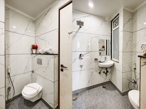 Experience a luxurious bathroom retreat with a clean design, featuring a toilet, sink, and glass-enclosed shower.