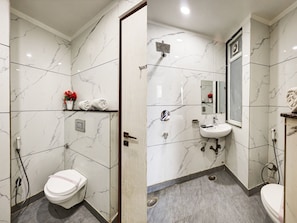 Experience a luxurious bathroom retreat with a clean design, featuring a toilet, sink, and glass-enclosed shower.